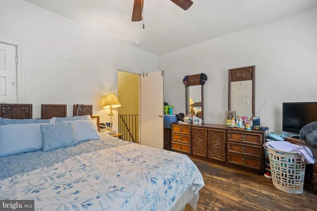 a bedroom with a bed and a large mirror on the dresser