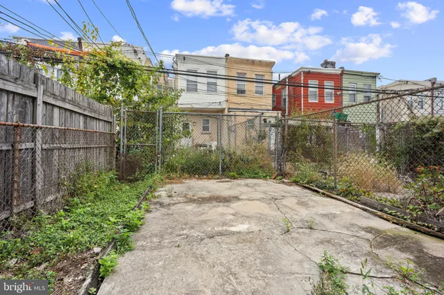 a view of a house with a yard and wooden fence