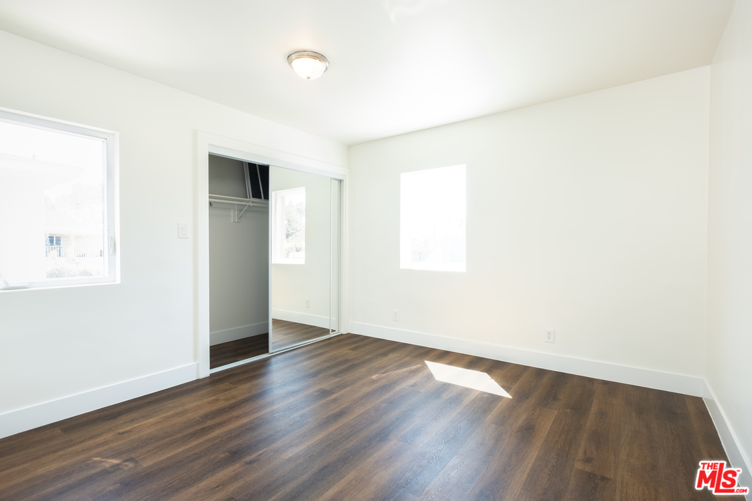 626 Silver Boulevard Los Angeles, CA 90026 - Photo 11 of 24 an empty room with wooden floor and windows