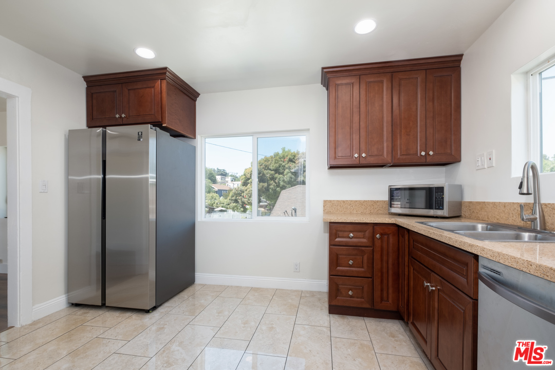 626 Silver Boulevard Los Angeles, CA 90026 - Photo 17 of 24 a kitchen with stainless steel appliances granite countertop a refrigerator and a sink