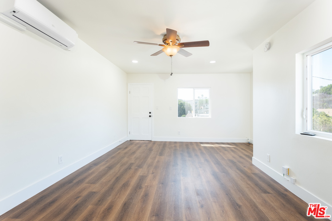 626 Silver Boulevard Los Angeles, CA 90026 - Photo 6 of 24 an empty room with wooden floor chandelier fan and windows