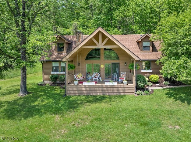 View of front of house featuring a front lawn and roof with shingles