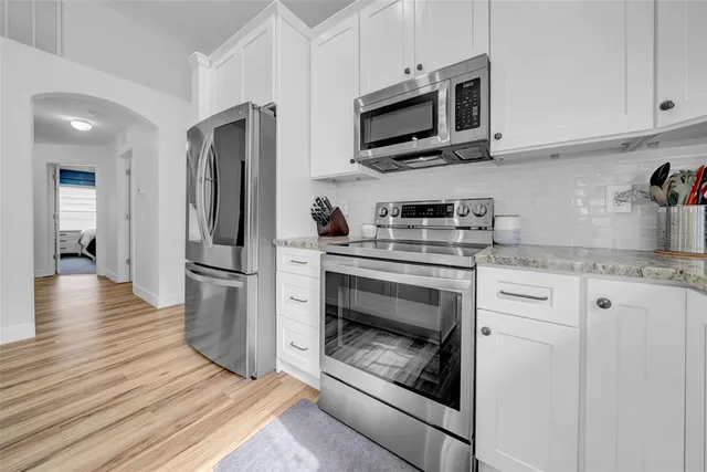 a kitchen with appliances a refrigerator and cabinets
