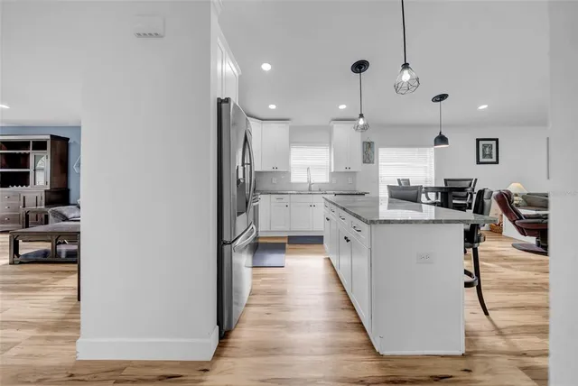a kitchen with kitchen island granite countertop a sink appliances and cabinets