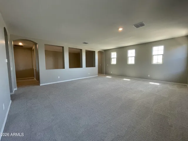 a view of an empty room with window and stairs