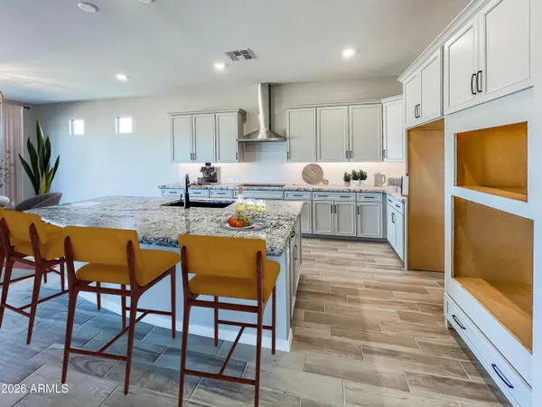 a kitchen with refrigerator and chairs