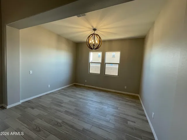 a view of empty room with wooden floor and window