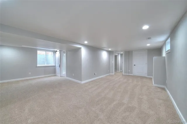 a view of an empty room and window and cabinet area
