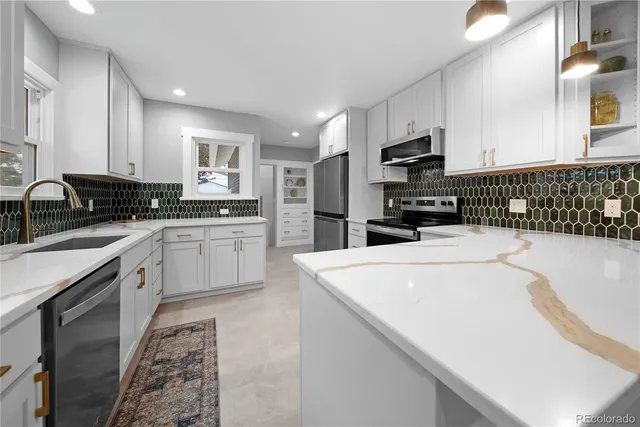 a kitchen with stainless steel appliances a sink a stove a microwave a center island and cabinets