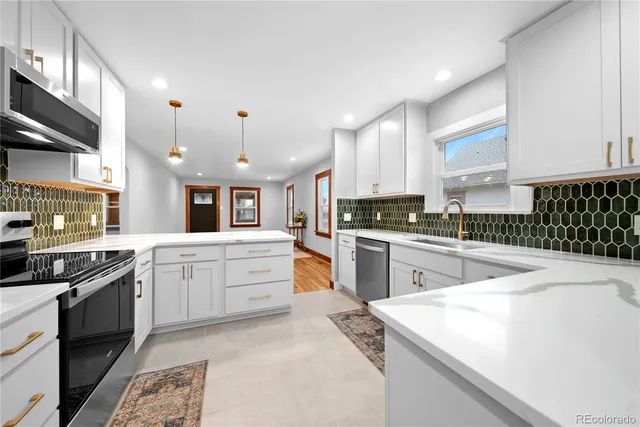 a kitchen with granite countertop a sink stove cabinets and refrigerator