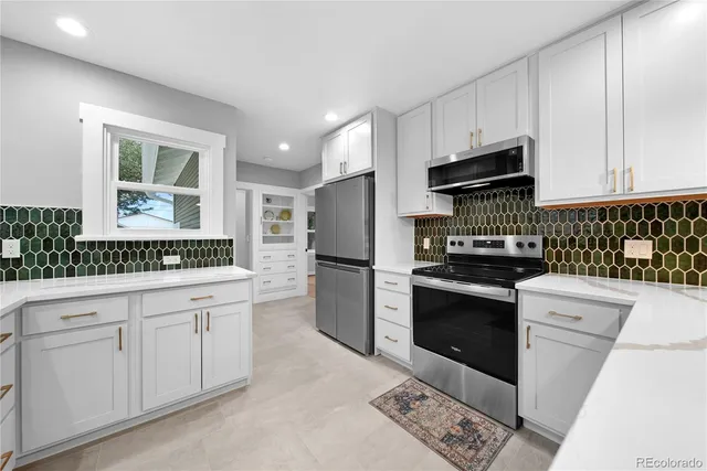 a kitchen with white cabinets and appliances