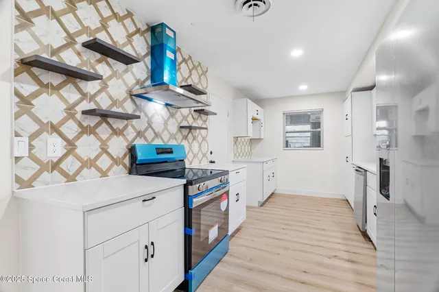 a kitchen with stainless steel appliances a stove a sink and a refrigerator