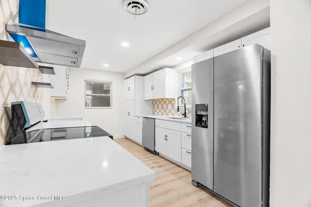 a kitchen with granite countertop a refrigerator and a sink
