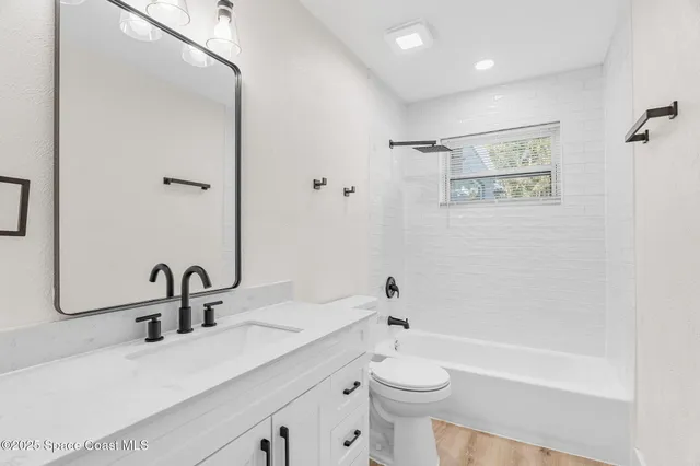 a bathroom with a sink a toilet and a large mirror