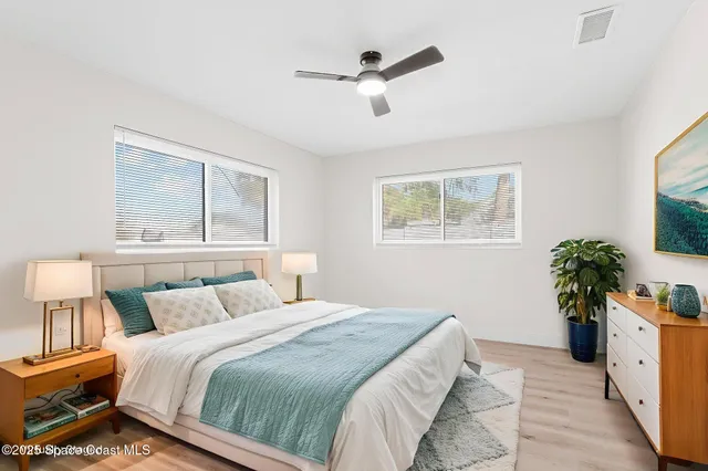 a bedroom with a large bed and a potted plant