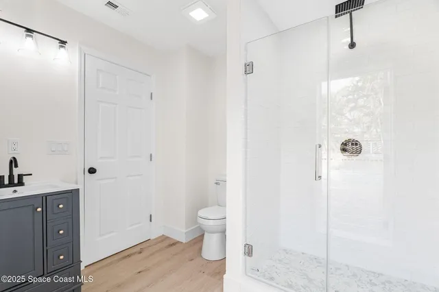a bathroom with a granite countertop sink a toilet and shower