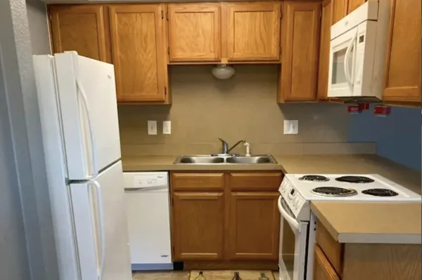 a kitchen with a sink a refrigerator and a stove