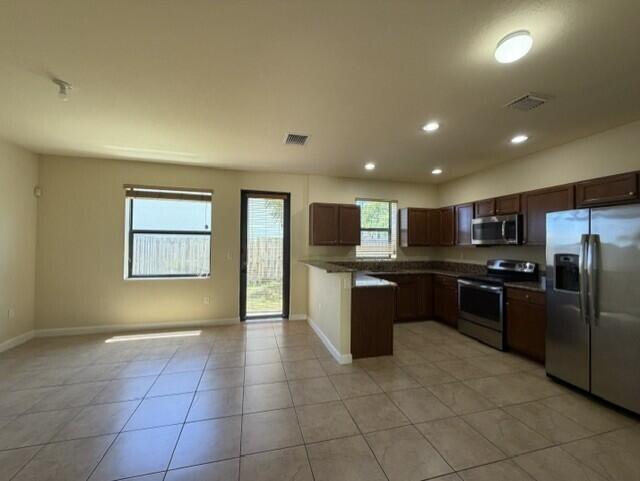 23765 Southwest 118 Avenue, Unit 23765 Homestead, FL 33032 - Photo 5 of 36 a large kitchen with a large counter top stainless steel appliances and a window