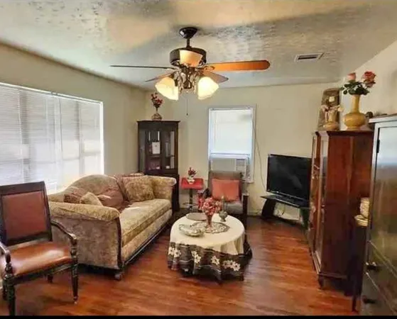 a living room with furniture a flat screen tv and a window