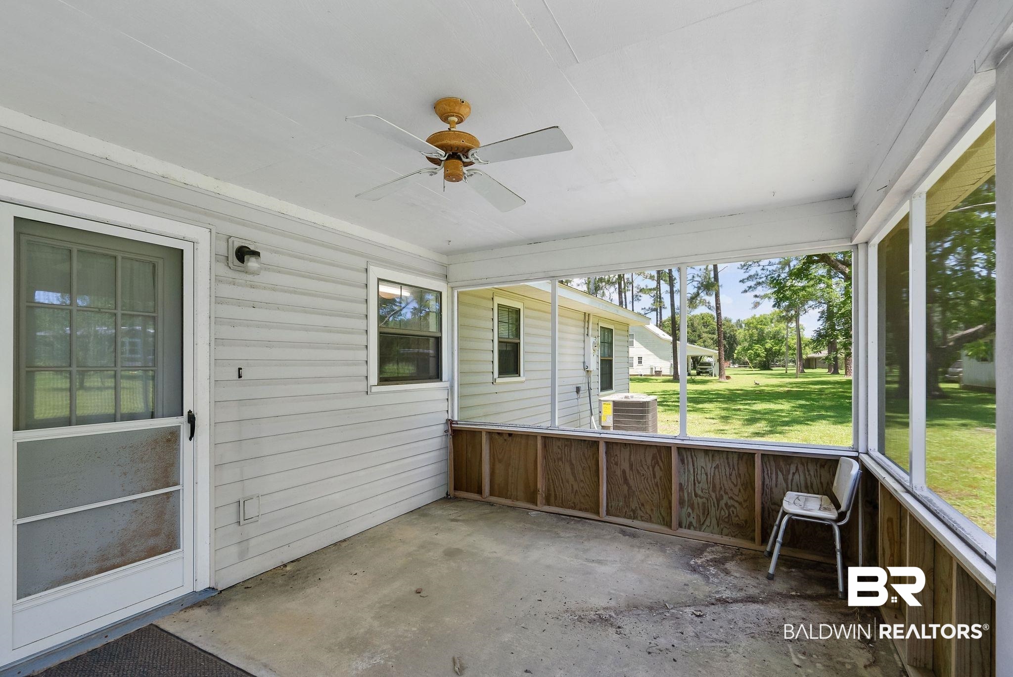 20540 Lacey Road Silverhill, AL 36576 - Photo 20 of 40 Screened porch featuring a ceiling fan, concrete flooring, exterior siding, and a screened door
