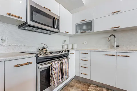 a kitchen with cabinets stainless steel appliances and a sink