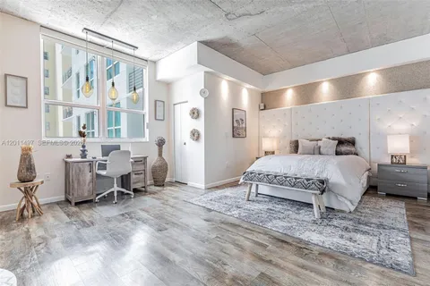 a spacious bedroom with a bed a table and chair