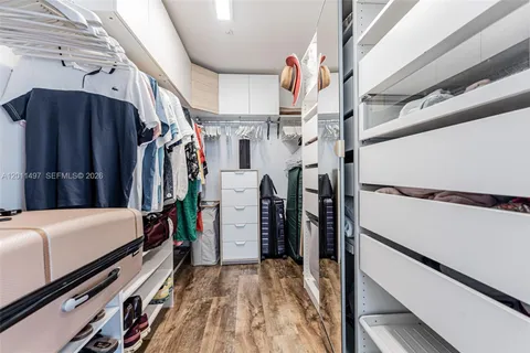 a view of walk in closet with clothes and shoes