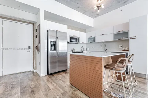 a kitchen with stainless steel appliances granite countertop a stove top oven a refrigerator a sink dishwasher with a dining table and chairs