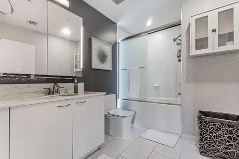 a bathroom with a granite countertop sink a toilet and a mirror