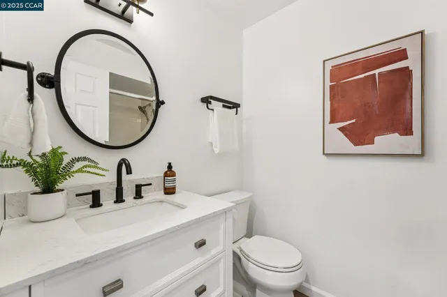 a bathroom with a shower sink vanity mirror and toilet