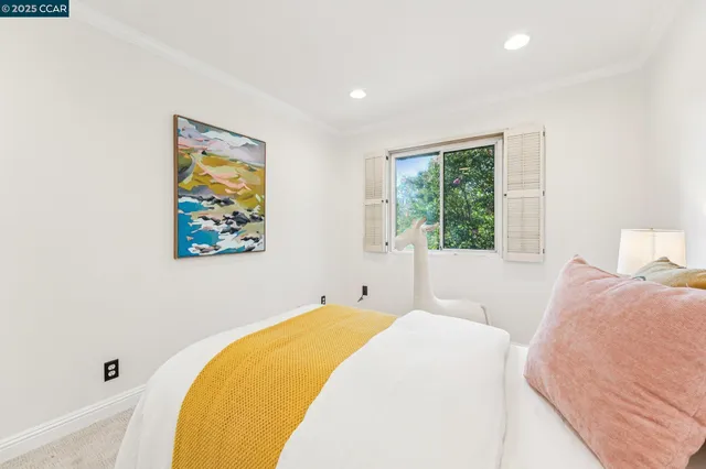 a spacious bedroom with a bed and a painting on the wall