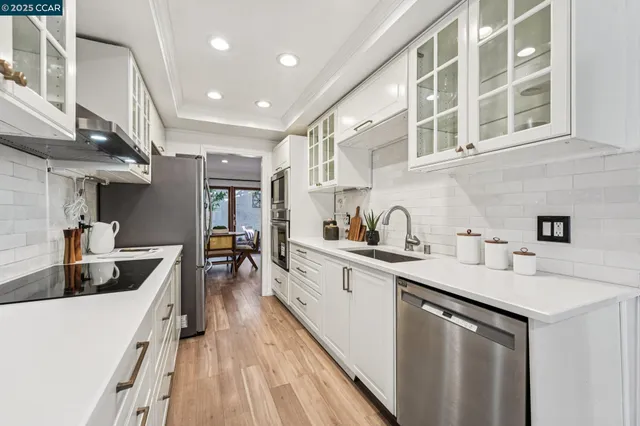 a kitchen with stainless steel appliances kitchen island granite countertop a refrigerator and a stove top oven