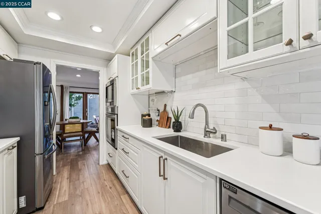 a kitchen with a white cabinets and wooden floor