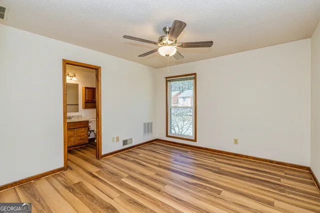 a view of a room with wooden floor and a ceiling fan