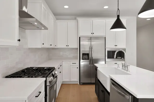 a kitchen with stainless steel appliances a sink stove and refrigerator