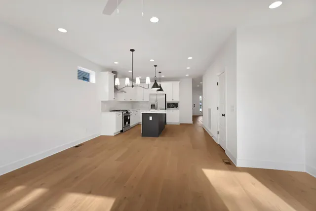 a large kitchen with kitchen island a stove a chimney a sink and a refrigerator