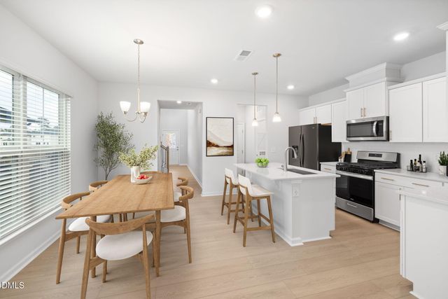 a kitchen with kitchen island a stove and a white cabinets