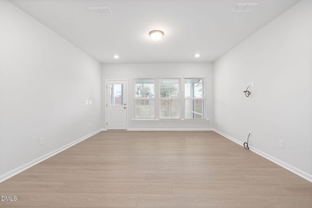 an empty room with a refrigerator and a fireplace