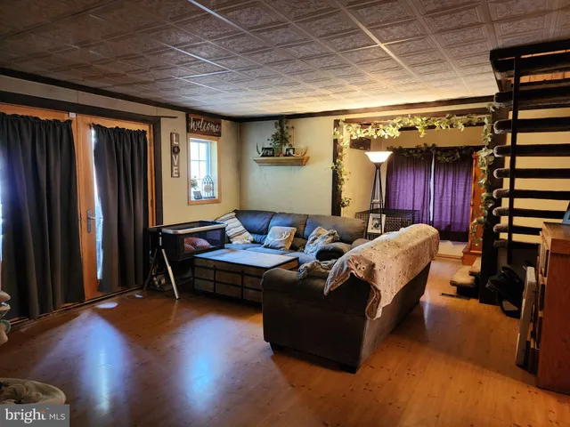 a living room with furniture a window and wooden floor
