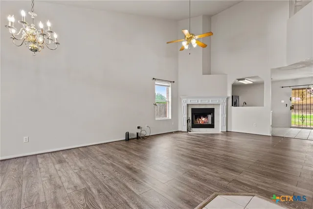 a view of a room with chandelier fireplace and wooden floor