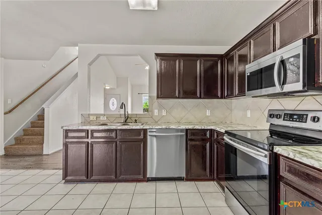 a kitchen with stainless steel appliances granite countertop a stove and a sink