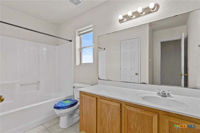 a bathroom with a granite countertop sink a toilet and a mirror