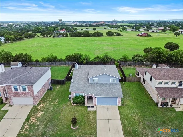 an aerial view of a house with big yard