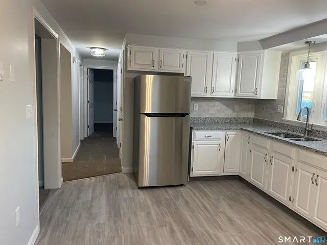 a kitchen with a refrigerator sink and cabinets