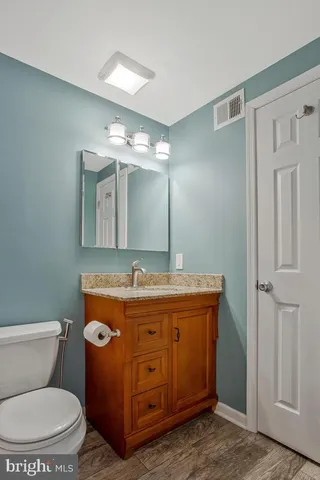 a bathroom with a toilet a sink and mirror