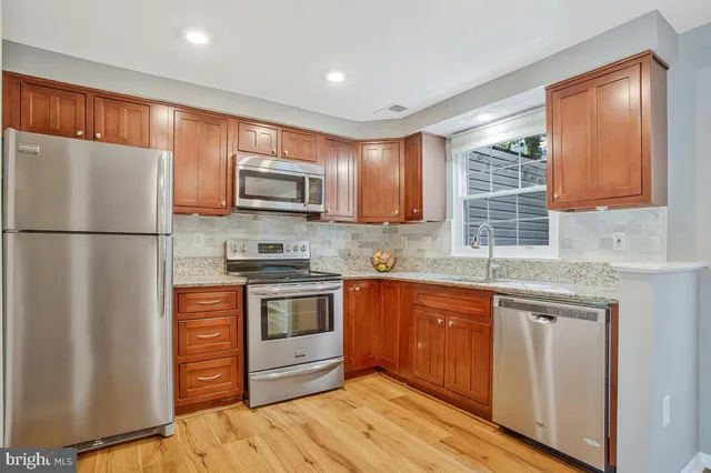 a kitchen with stainless steel appliances granite countertop a refrigerator stove a sink dishwasher and microwave