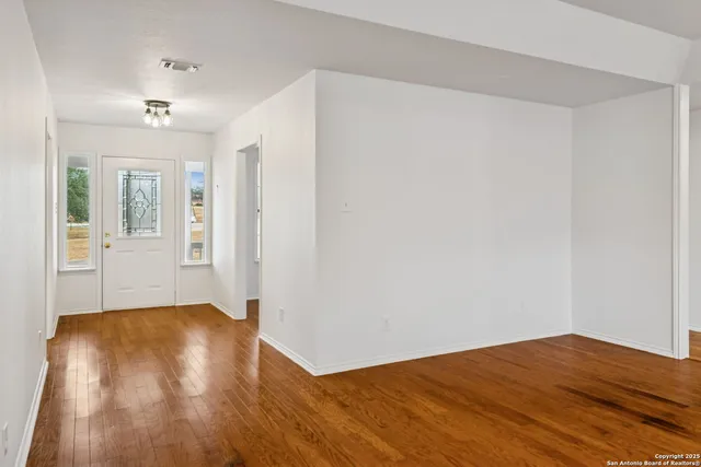 a kitchen with kitchen island granite countertop a sink a stove and white cabinets