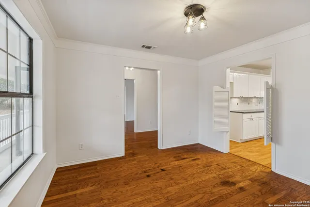 a view of a hallway with wooden floor and a bathroom