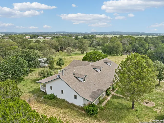 an aerial view of a house with a garden and lake view