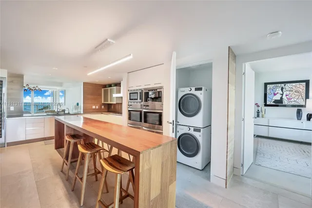 a kitchen with kitchen island a stove a table and chairs